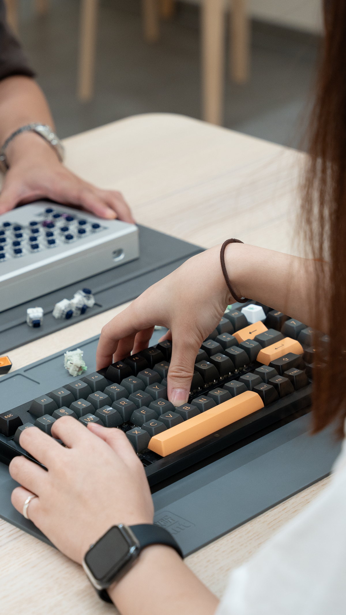 Hands assembling a custom mechanical keyboard during a workshop